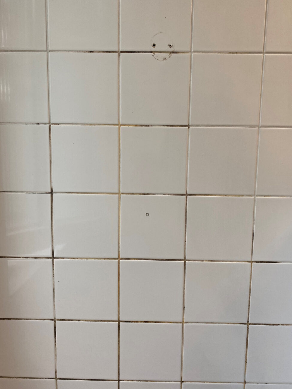 Dusche mit stark verschmutzten Zementfugen vor der Reinigung